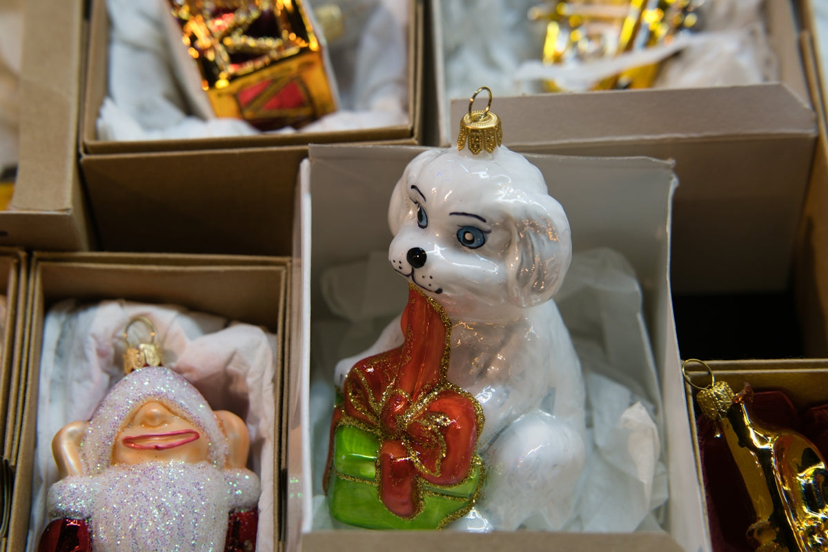 Glass christmas ornaments of a white dog and santa.